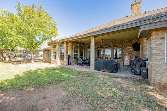 rear view of house with a lawn, ceiling fan, and a patio