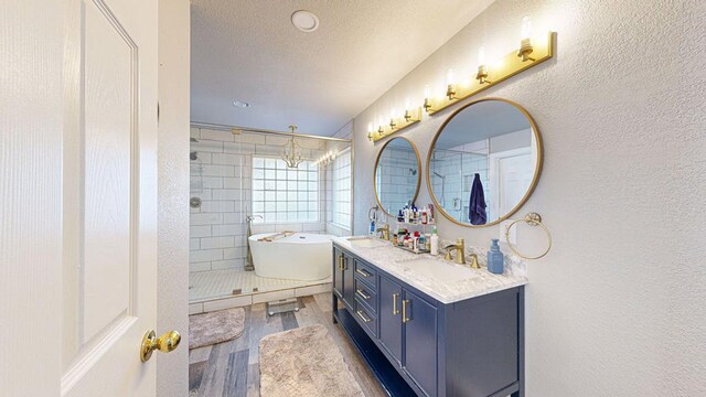 bathroom with a chandelier, hardwood / wood-style floors, a textured ceiling, and shower with separate bathtub