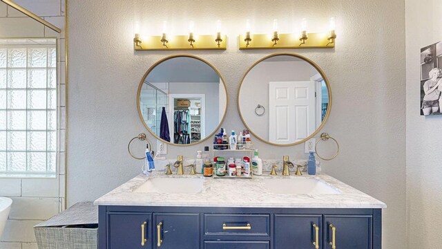 bathroom with a wealth of natural light, a washtub, and vanity