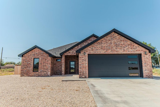 1708 E Main St, Brownfield, TX 79316 - view of front facade featuring brick siding, concrete driveway, an attached garage, and roof with shingles