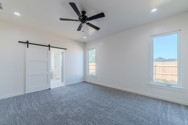 1708 E Main St, Brownfield, TX 79316 - carpeted spare room with a barn door, baseboards, a ceiling fan, and recessed lighting