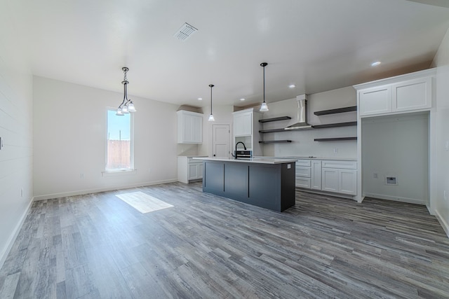 1708 E Main St, Brownfield, TX 79316 - kitchen featuring open shelves, wood finished floors, recessed lighting, wall chimney range hood, and a center island with sink
