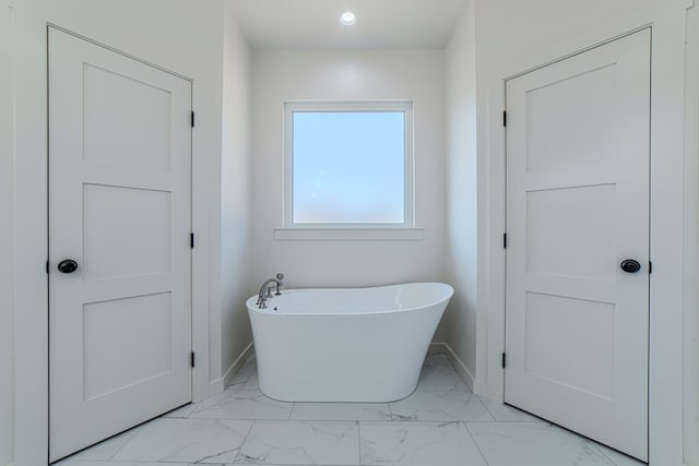 1708 E Main St, Brownfield, TX 79316 - bathroom with marble look tile flooring, a soaking tub, baseboards, and recessed lighting