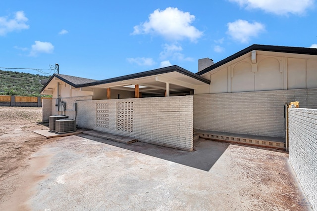 905 Mountain Park Dr, Big Spring, TX 79720 - rear view of house featuring brick siding, fence, and a chimney