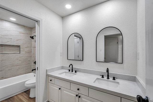905 Mountain Park Dr, Big Spring, TX 79720 - full bath with toilet, wood finished floors, double vanity, and shower / bath combination