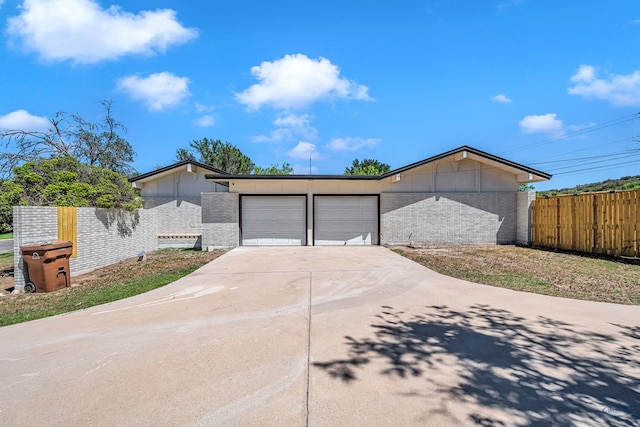 905 Mountain Park Dr, Big Spring, TX 79720 - view of front of house with brick siding, fence, a garage, and concrete driveway