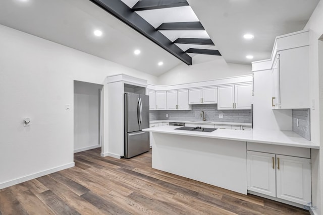 905 Mountain Park Dr, Big Spring, TX 79720 - kitchen with appliances with stainless steel finishes, a sink, a peninsula, decorative backsplash, and light countertops