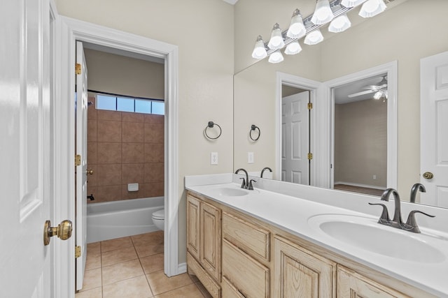 full bathroom featuring tile patterned flooring, vanity, tiled shower / bath, and toilet