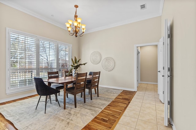 dining room featuring crown molding, a chandelier, and light hardwood / wood-style floors