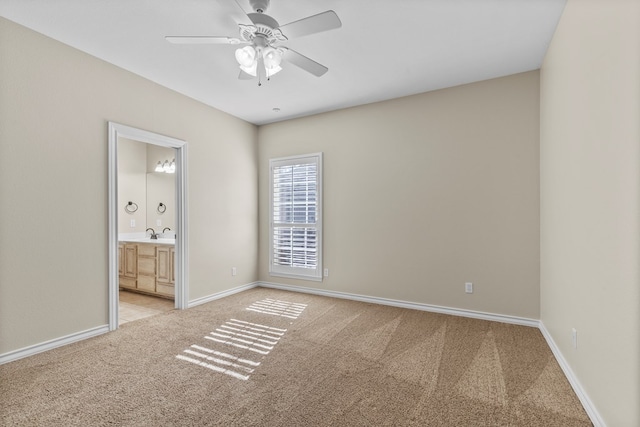 unfurnished bedroom with ensuite bath, light colored carpet, and ceiling fan