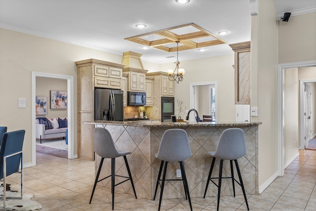 kitchen featuring stone counters, decorative backsplash, black appliances, crown molding, and cream cabinets