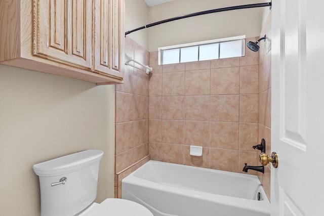 bathroom with tiled shower / bath combo and toilet