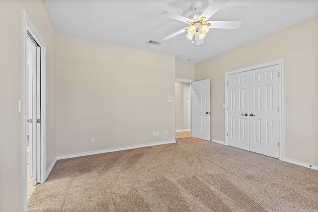 unfurnished bedroom with light colored carpet, a closet, and ceiling fan