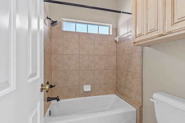 bathroom with toilet and tiled shower / bath combo