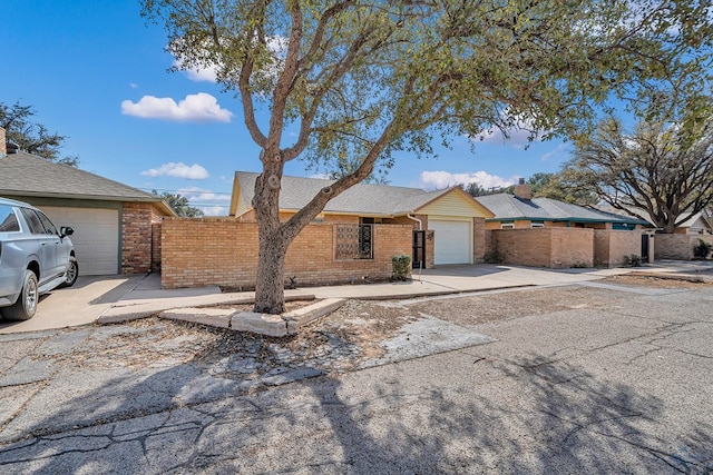 ranch-style home featuring a garage, concrete driveway, and brick siding