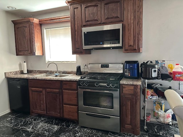 kitchen featuring appliances with stainless steel finishes, dark brown cabinetry, and sink