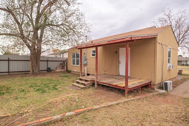 back of property featuring cooling unit and a lawn