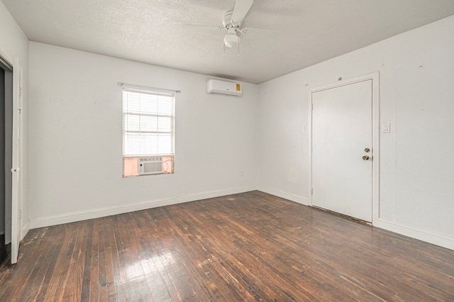 empty room with ceiling fan, dark hardwood / wood-style floors, a wall mounted AC, cooling unit, and a textured ceiling