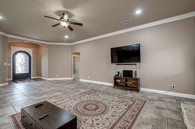 kitchen featuring arched walkways, baseboards, crown molding, light stone countertops, and double oven