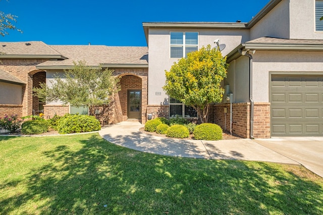 1221 Porterfield Rd, Midland, TX 79705 - view of front of property with a front yard, brick siding, a garage, and stucco siding