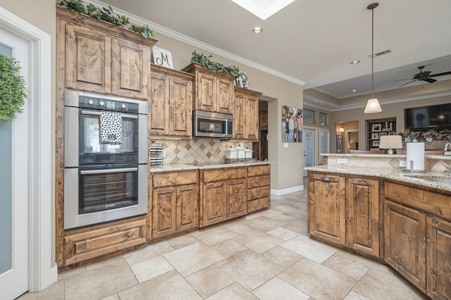 kitchen featuring light stone countertops, decorative light fixtures, stainless steel appliances, decorative backsplash, and ornamental molding