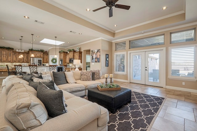 living room featuring a skylight, french doors, crown molding, and a tray ceiling