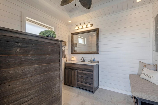 bathroom with wooden walls, ceiling fan, and vanity