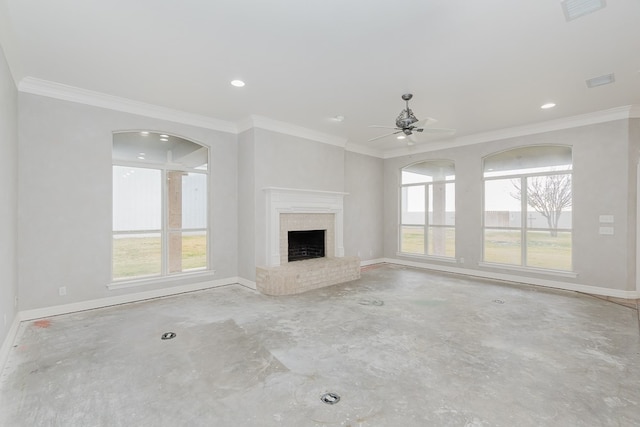 unfurnished living room with a brick fireplace, ceiling fan, plenty of natural light, and ornamental molding