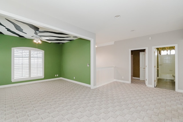 unfurnished room with ceiling fan and light colored carpet