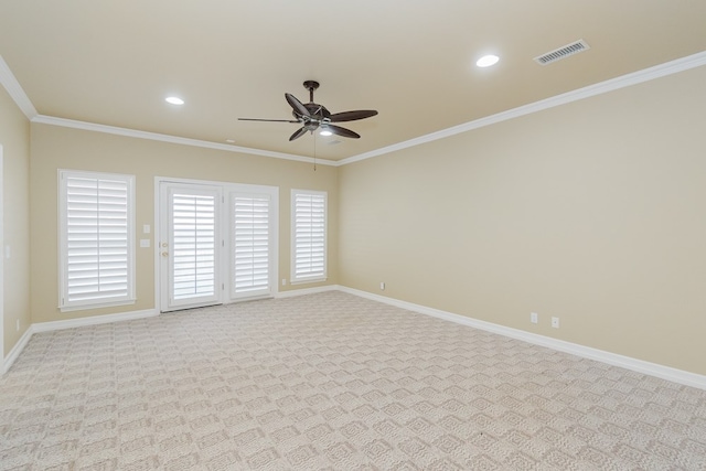 carpeted spare room with crown molding and ceiling fan