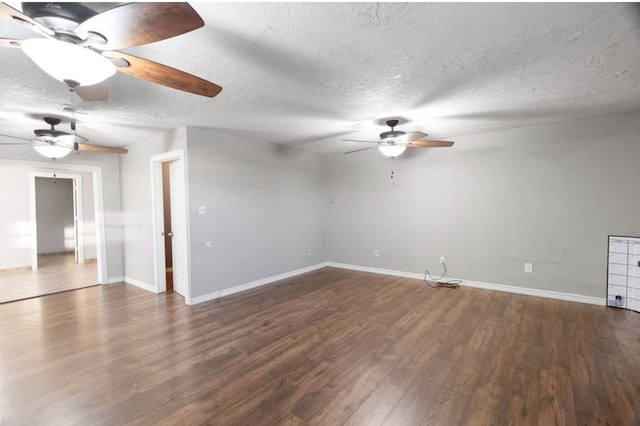 empty room with a textured ceiling and dark wood-type flooring