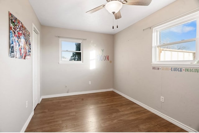 empty room with ceiling fan and dark wood-type flooring