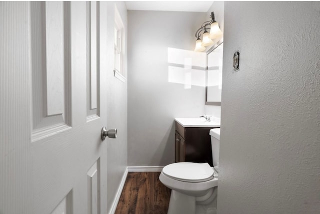 bathroom featuring vanity, hardwood / wood-style flooring, and toilet