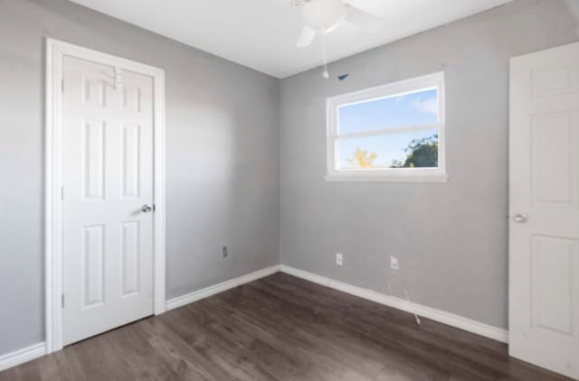 unfurnished bedroom with a closet, dark hardwood / wood-style floors, and ceiling fan