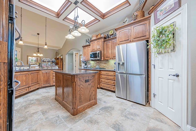 kitchen featuring a center island, stainless steel appliances, an inviting chandelier, backsplash, and decorative light fixtures