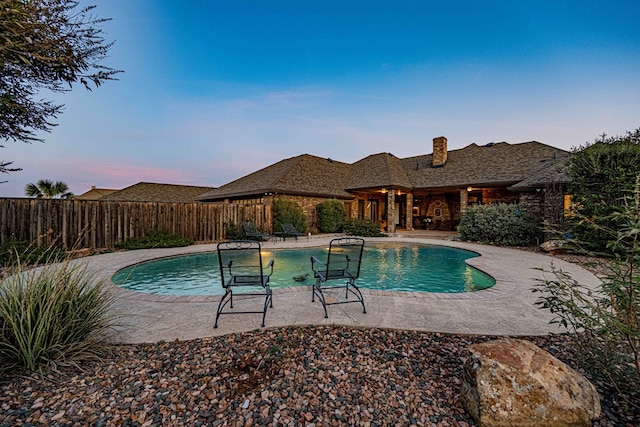 pool at dusk featuring a patio area