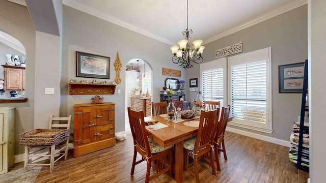 dining area featuring dark hardwood / wood-style floors, an inviting chandelier, and crown molding