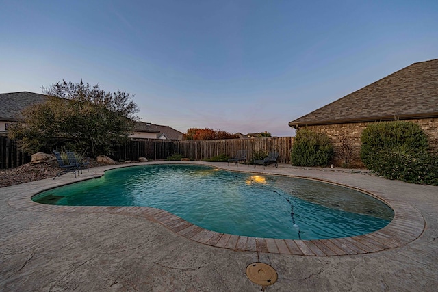 pool at dusk with a patio