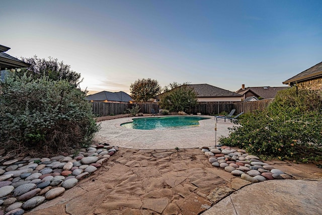 pool at dusk featuring a patio area