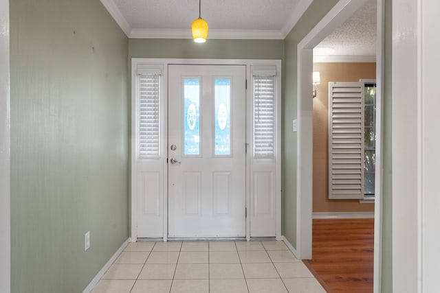 entrance foyer featuring plenty of natural light, light tile patterned flooring, a textured ceiling, and ornamental molding