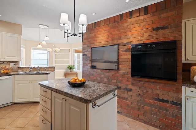 kitchen with a kitchen island, sink, decorative light fixtures, dishwasher, and oven