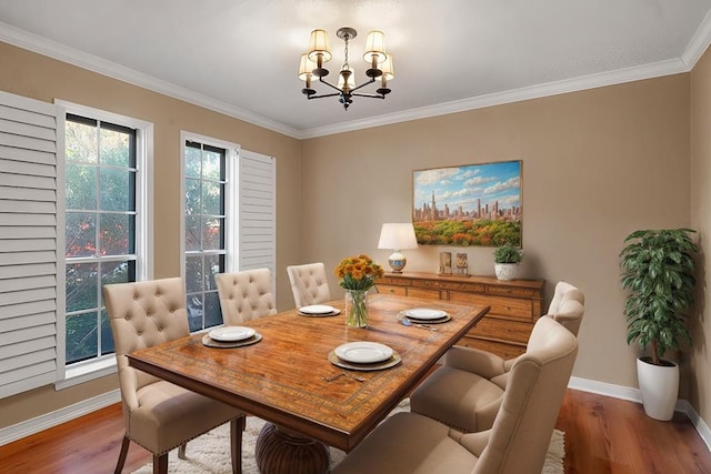 dining room featuring hardwood / wood-style flooring, crown molding, and a chandelier