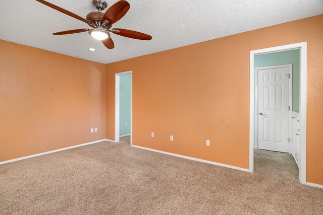 spare room with ceiling fan, carpet, and a textured ceiling