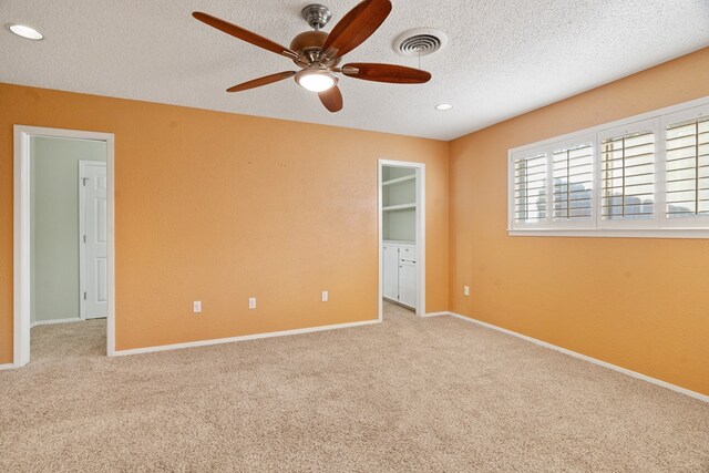 unfurnished bedroom with light carpet, a textured ceiling, and ceiling fan