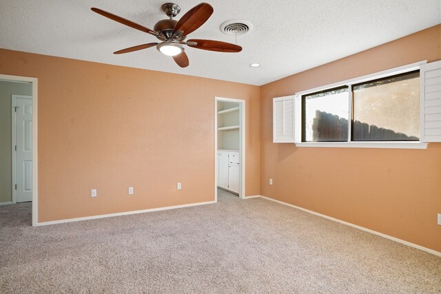 unfurnished bedroom with carpet flooring, a textured ceiling, and ceiling fan