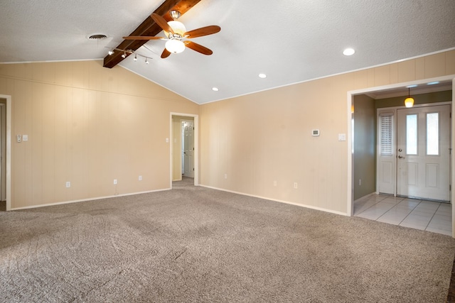 empty room with vaulted ceiling with beams, ceiling fan, light colored carpet, and a textured ceiling