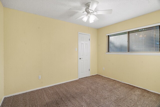 carpeted spare room with ceiling fan and a textured ceiling