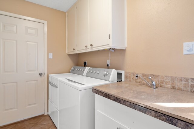 laundry area with cabinets, independent washer and dryer, and light tile patterned floors