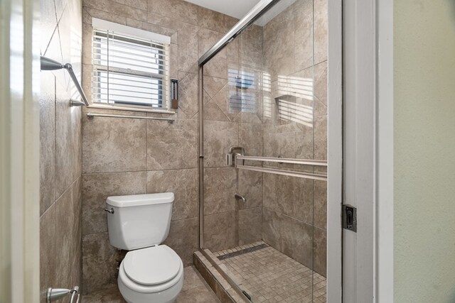 bathroom with tile patterned floors, an enclosed shower, and toilet