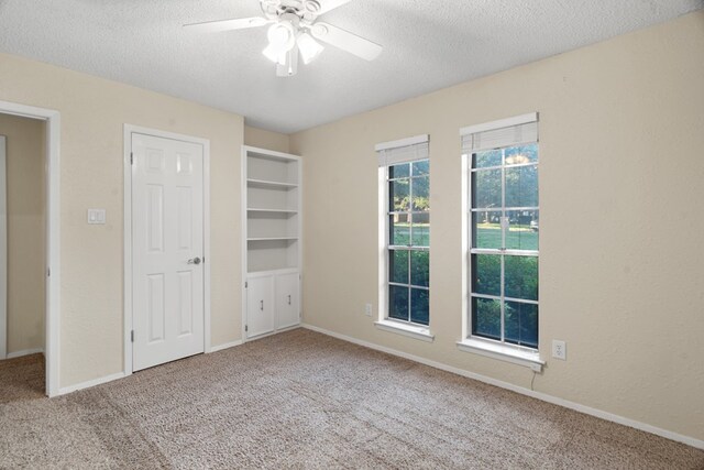 unfurnished bedroom with carpet flooring, a textured ceiling, and ceiling fan